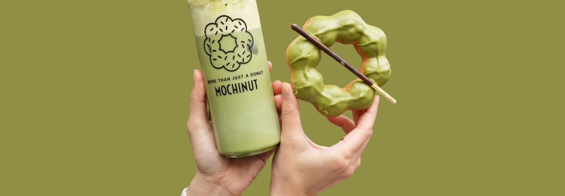 Matcha drink and mochi donut held in hands